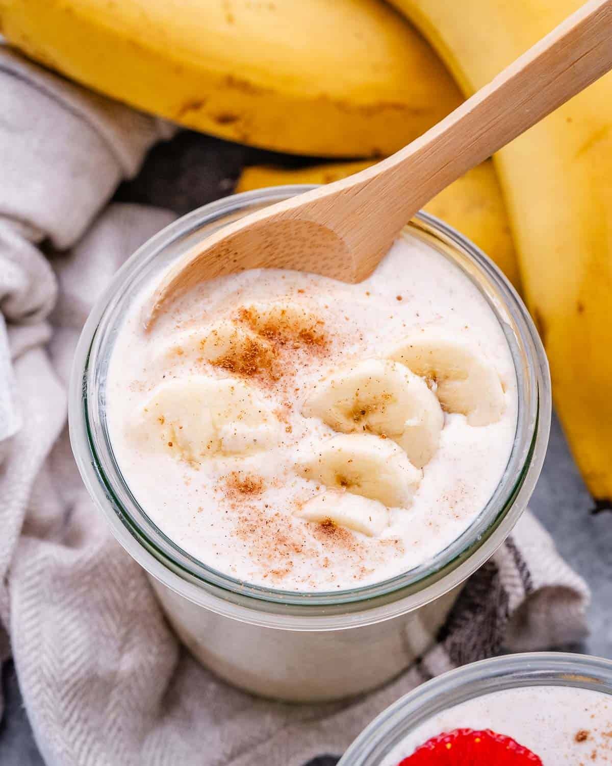 Close up image of blended rolled oats in a jar topped with banana slices