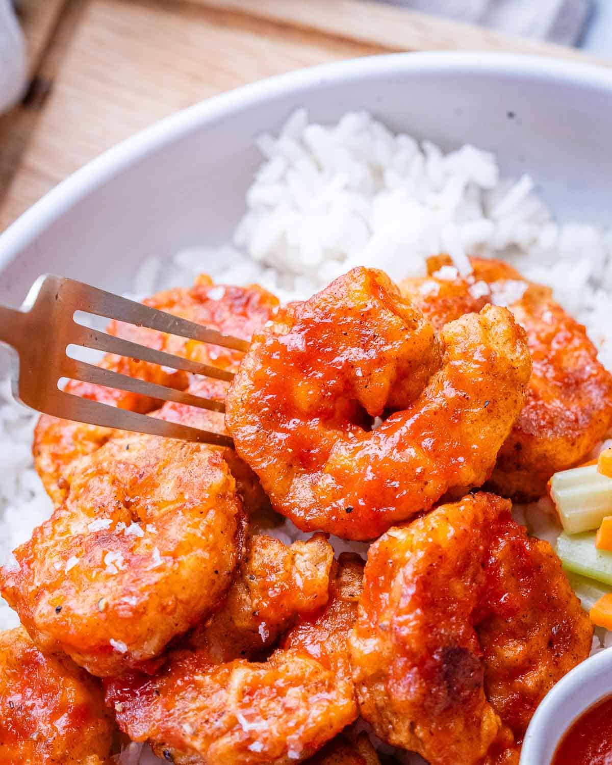 A closeup of buffalo shrimp on a fork