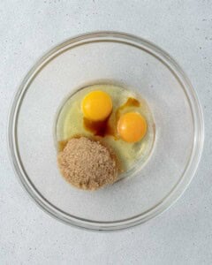 Eggs, sugar, and vanilla extract in a mixing bowl ready to be whisked for the brownie batter.