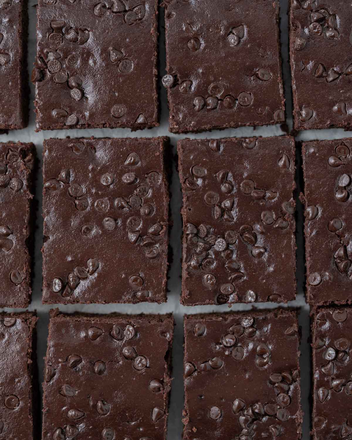 A close-up of a single brownie slice being held to show its soft, cake-like texture.