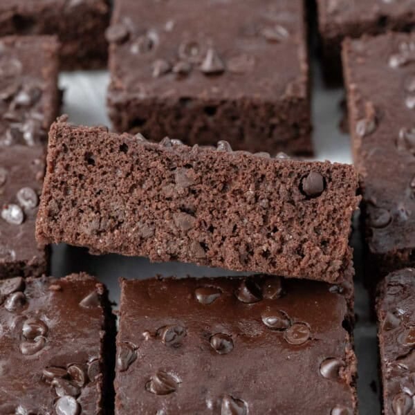 Stack of sliced Greek yogurt brownies showing a moist, fudgy interior with chocolate chips on top.