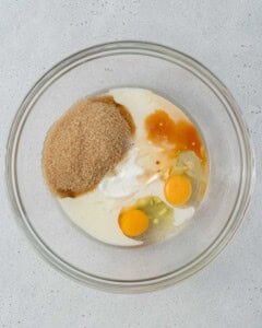 Wet ingredients and sugar added to a mixing bowl, ready to be whisked.