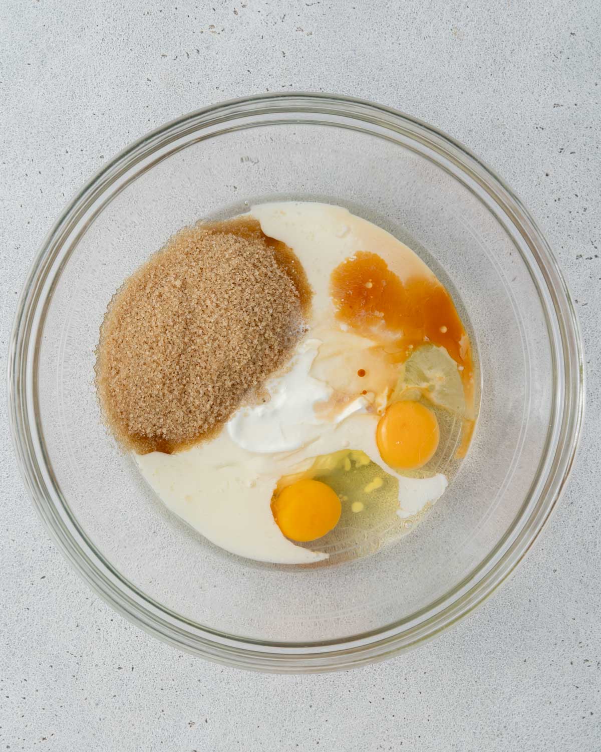 Wet ingredients and sugar added to a mixing bowl, ready to be whisked.