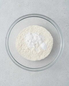 Bowl of dry ingredients including flour, baking powder, baking soda, and salt.
