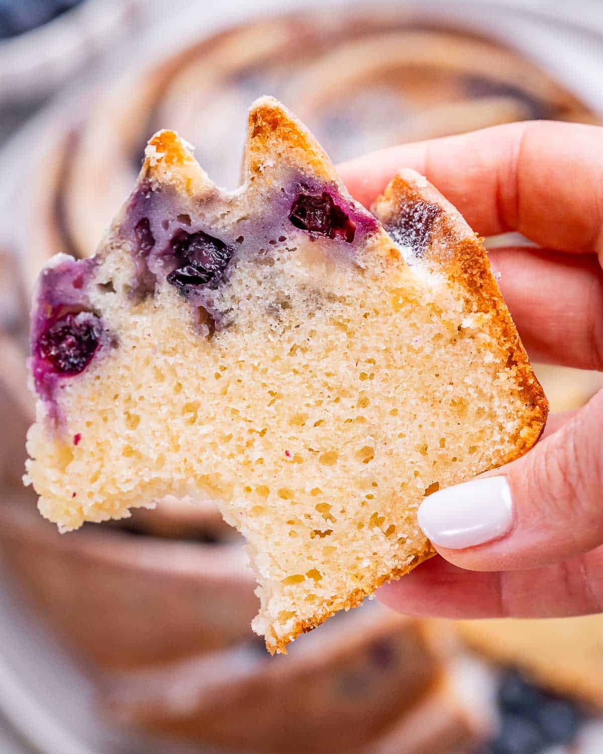a slice of blueberry lemon bundt cake with a bite taken out