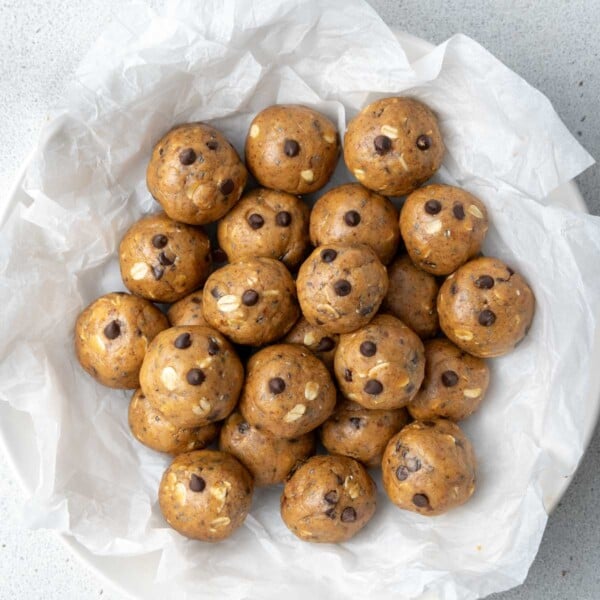 peanut butter protein balls on a parchment paper on a plate.