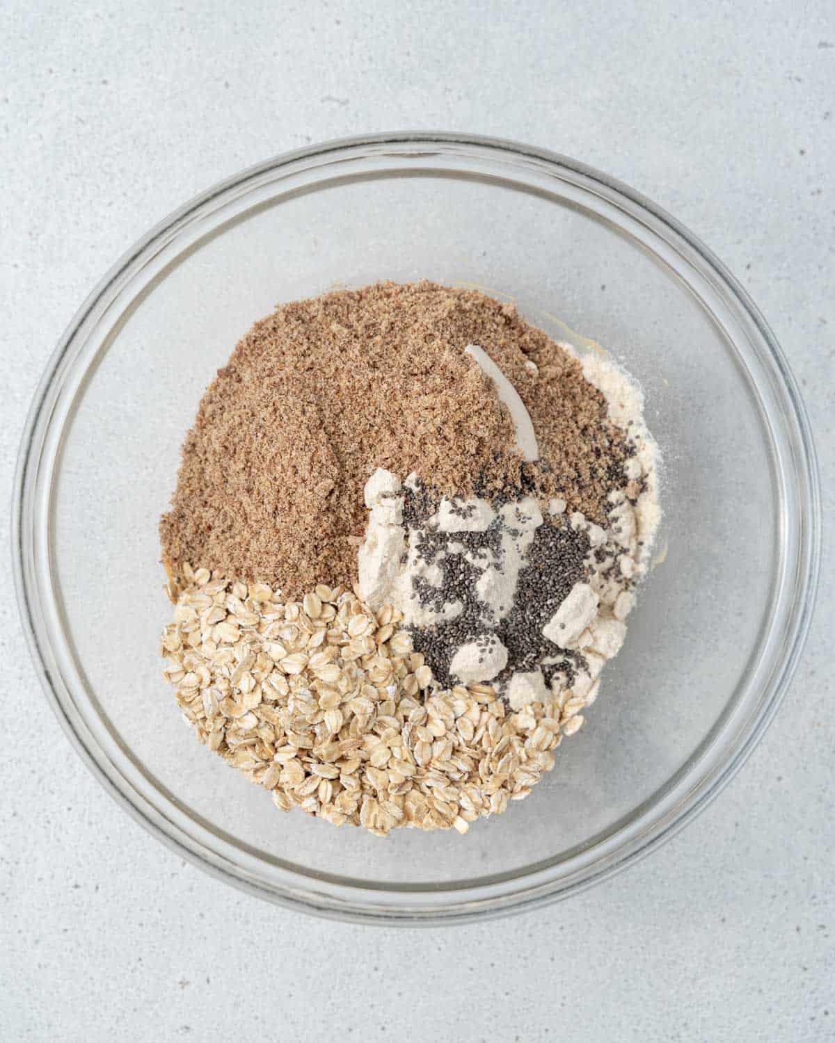 flax, oatmeal, and protein powder added over peanut butter in a bowl.