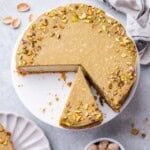 Cheesecake on a plate with a slice cut off.