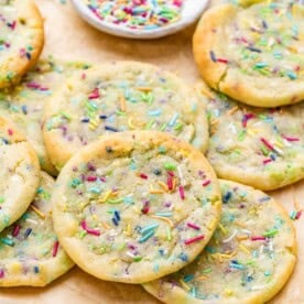 Close-up of baked cookies with rainbow sprinkles melted slightly into the tops.