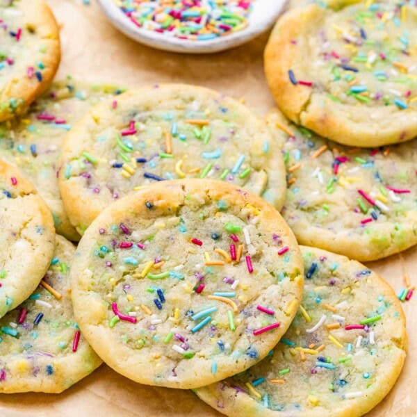 Close-up of baked cookies with rainbow sprinkles melted slightly into the tops.