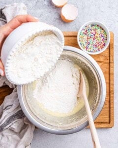 Flour mixture being poured into the wet ingredients to combine for the dough.