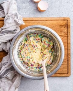 Cookie dough fully mixed with rainbow sprinkles folded in, ready to be shaped.