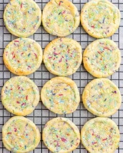 Wire cooling rack filled with sprinkle-topped birthday cake cookies.
