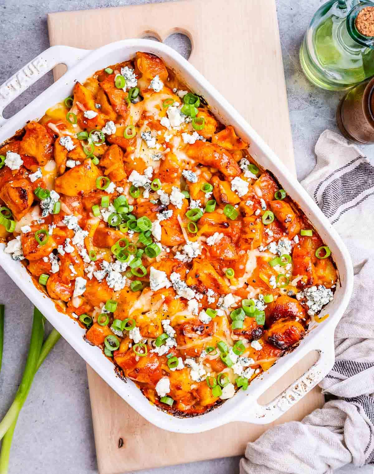 Buffalo chicken and potatoes in a casserole dish.