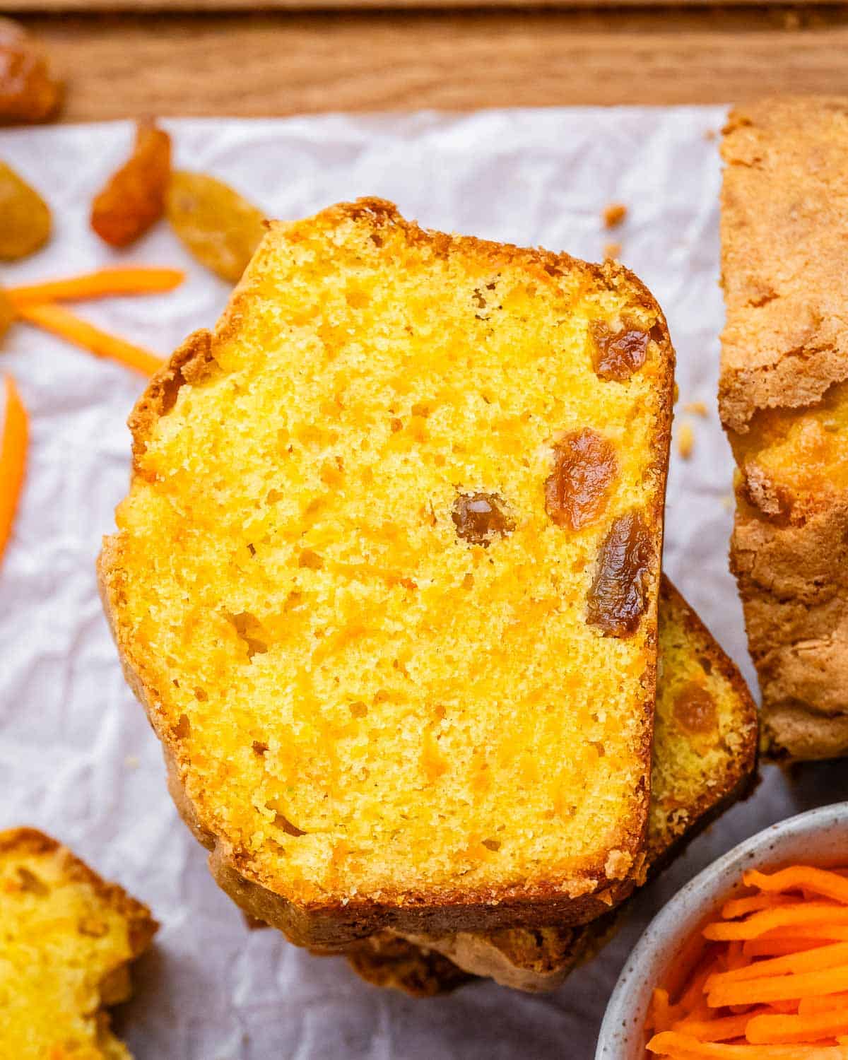 Close-up of sliced carrot cake loaf stacked together, showcasing its golden color and moist interior.