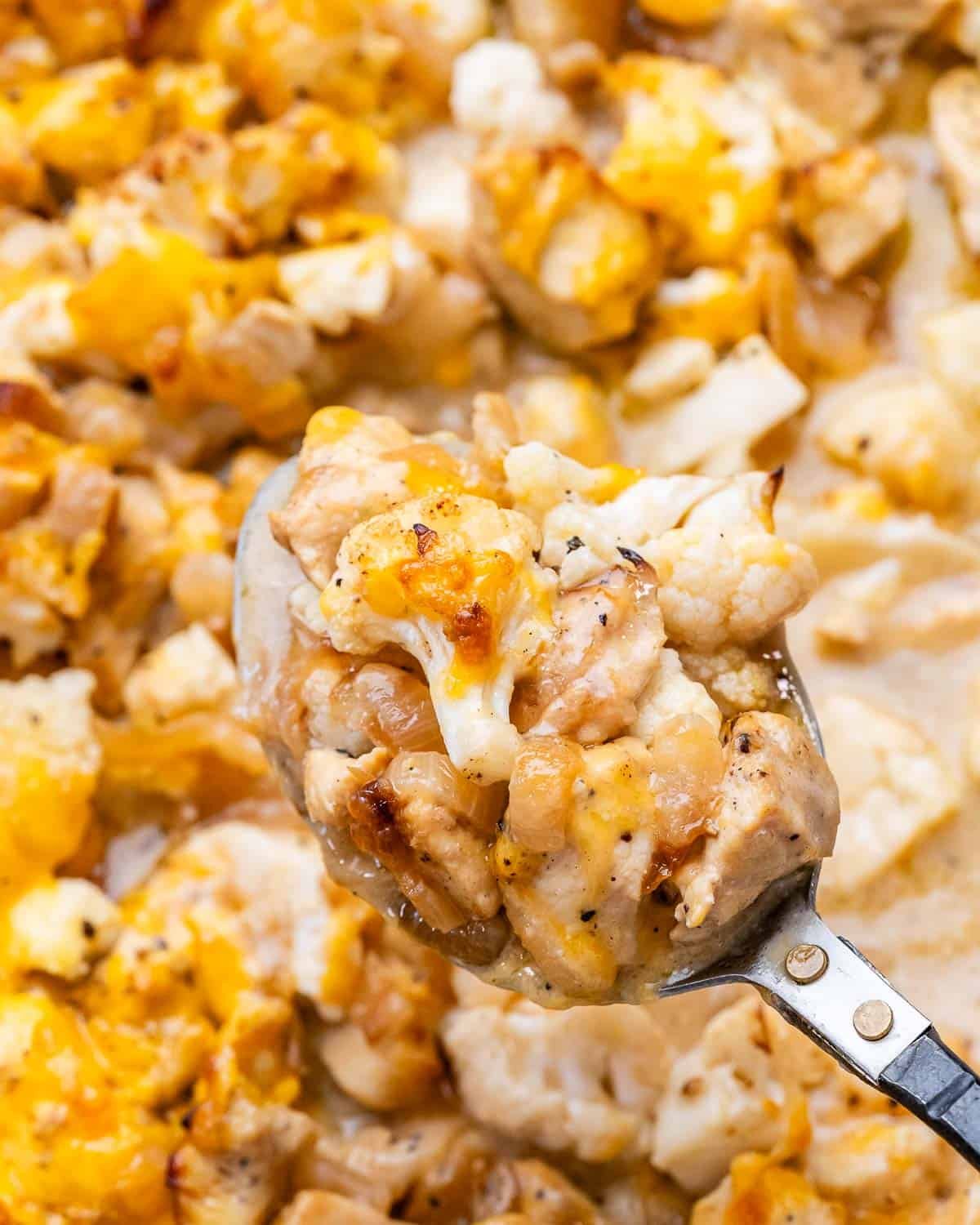 A spoonful of French onion chicken casserole over a dish
