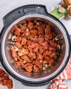 Seasoned beef chunks inside the Instant Pot before broth is added.