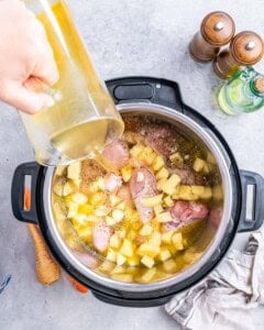 Chicken pieces, potatoes, and broth cooking together inside the Instant Pot.