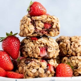 3 oatmeal cookies with strawberries stacked over each other.