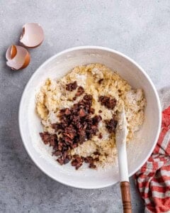 Cookie dough mixture in a white bowl with chopped dried strawberries folded in.