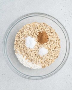 oats, flour, and seasoning added to a bowl.
