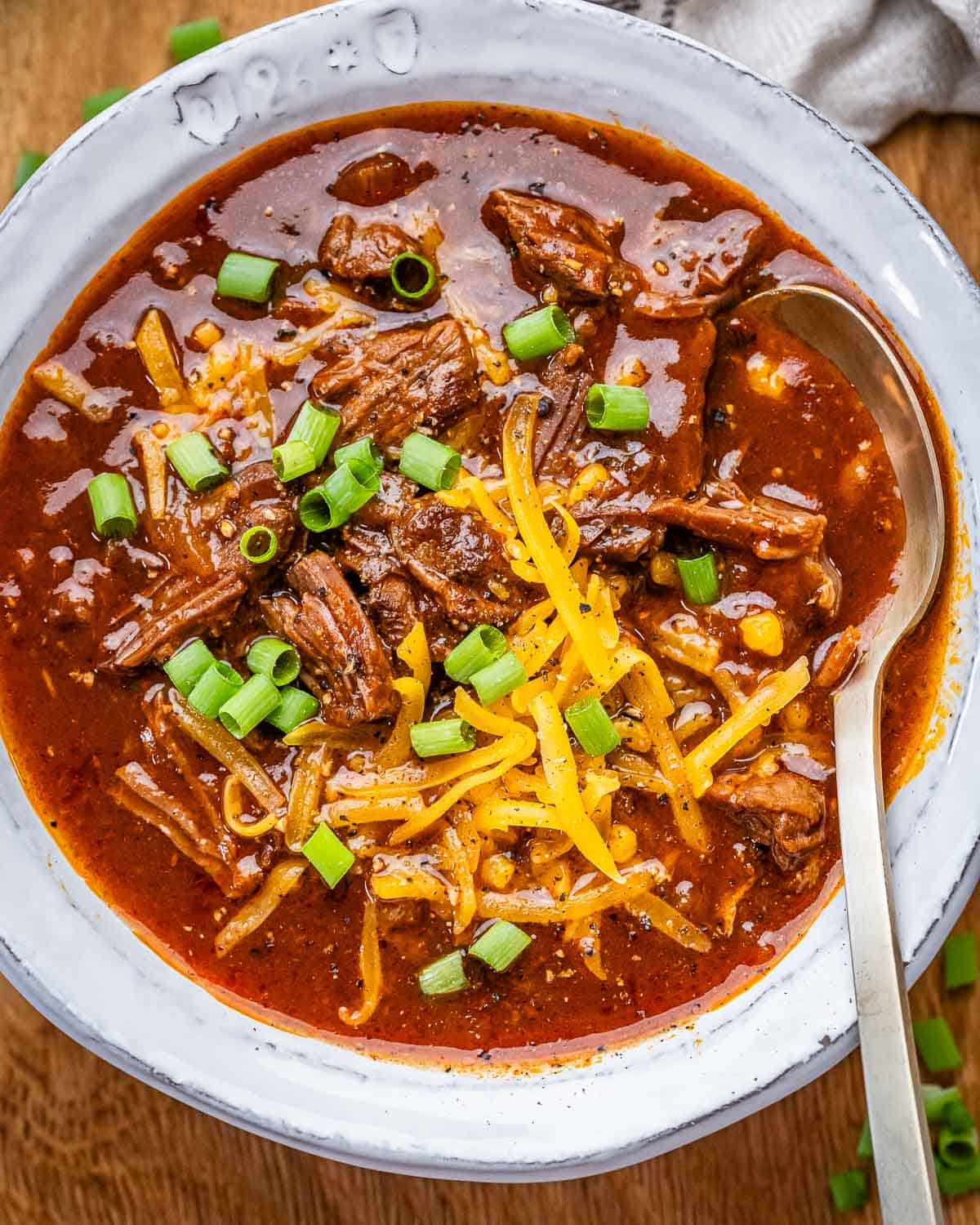 A white bowl of Texas Chili with a spoon