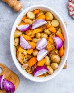 Overhead view of the seasoned chicken and vegetables, showing an even layer for perfect roasting.
