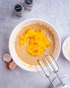pumpkin puree added over the egg mixture in a bowl.