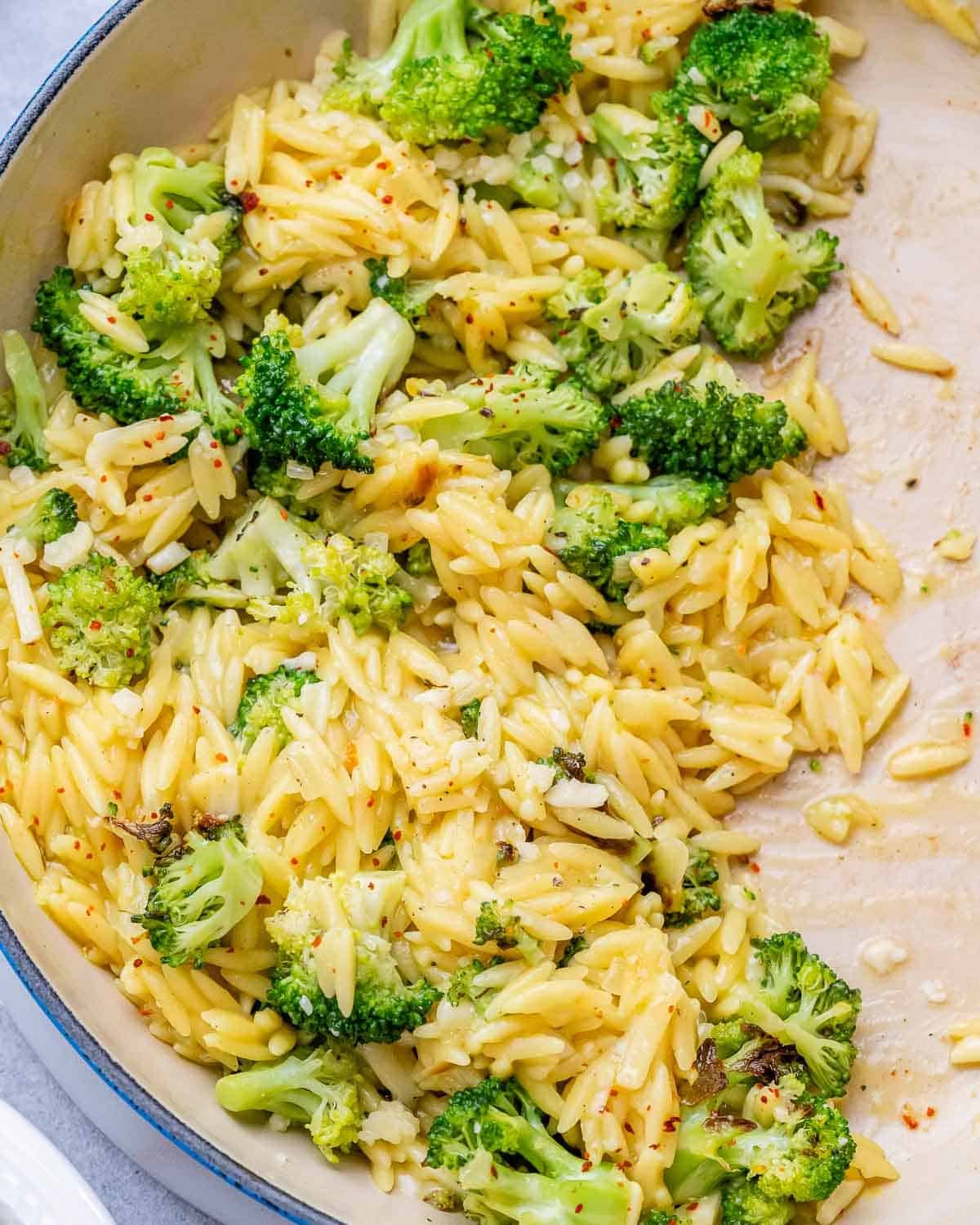 A close-up of broccoli cheddar orzo in a skillet.
