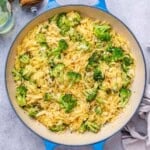 a skillet with orzo, cheese, and broccoli.