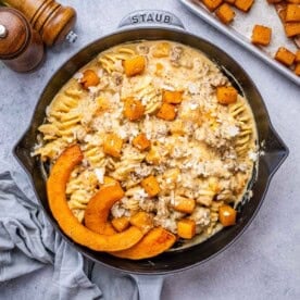 Butternut Squash Pasta served in a pan, with melted cheese and roasted squash glistening on top.