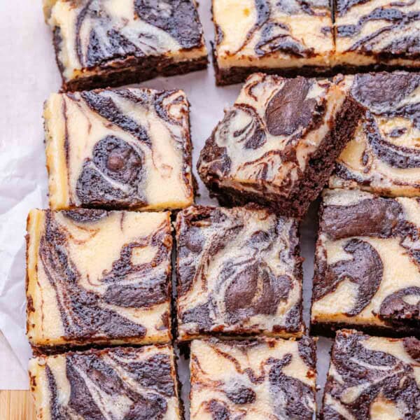 cheesecake brownie square bars on a flat surface.