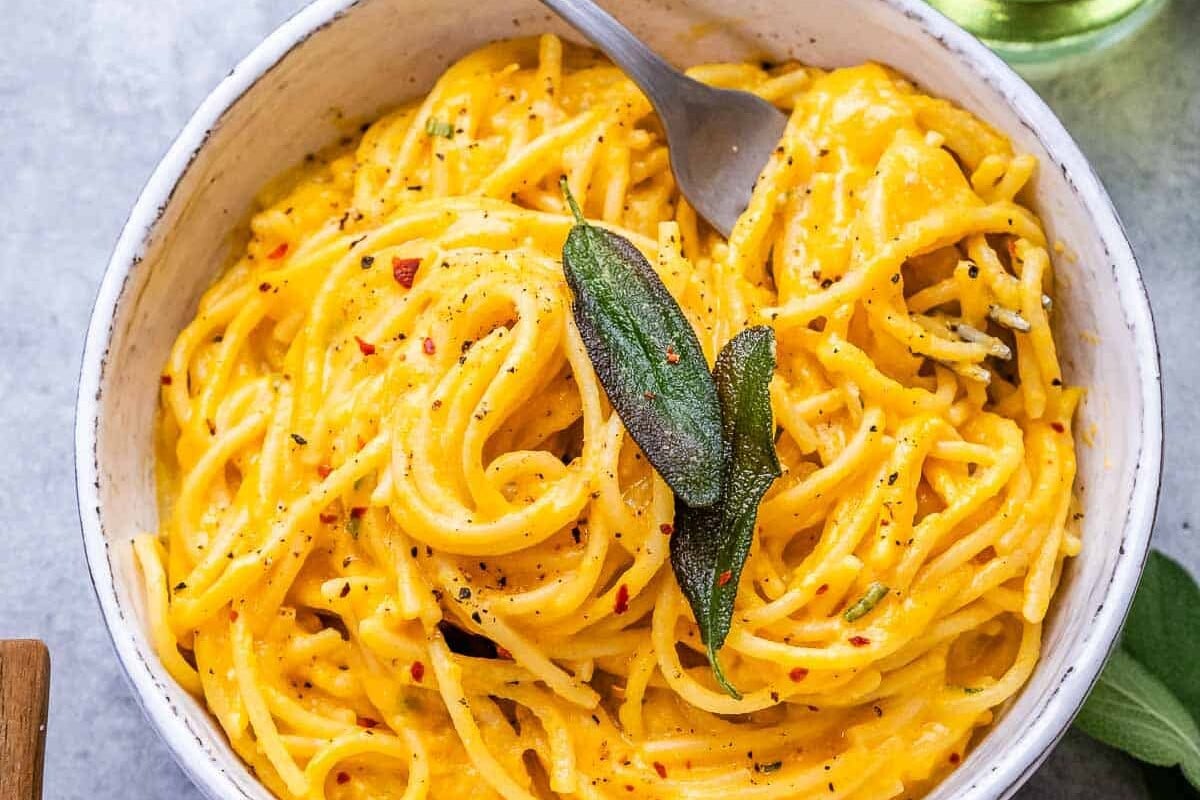 a bowl with pumpkin alfredo and fork in the bowl.