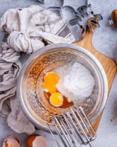 sugar, eggs, and oil in a bowl to be mixed for cookies.