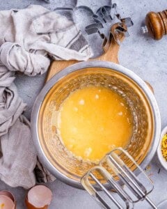 egg batter mixed in a bowl with an electric mixer for cookies.