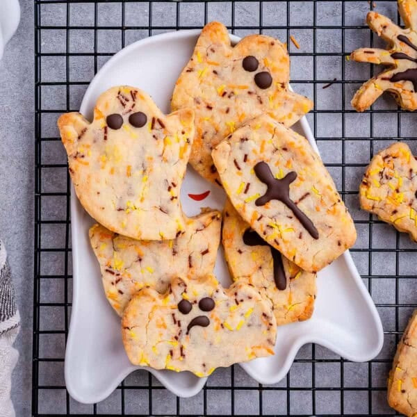 Halloween ghost and spider cookies on a plate.