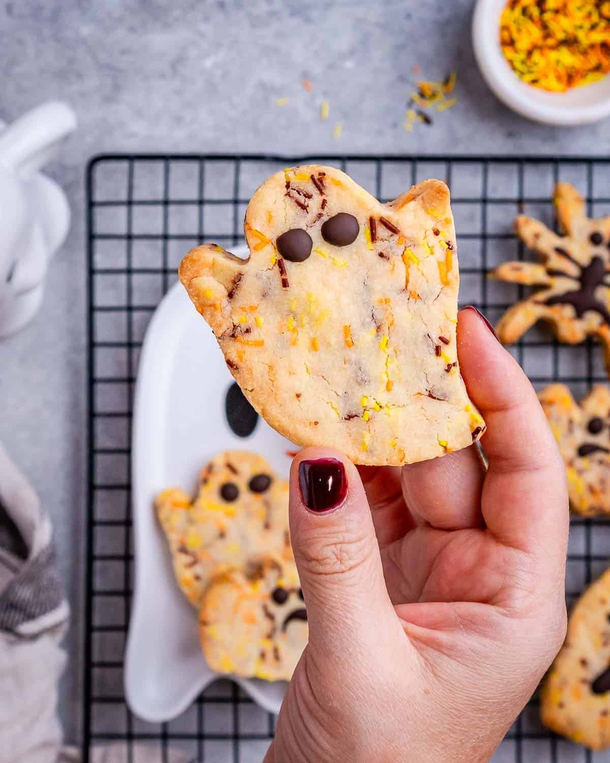 hand holding a Halloween ghost cookie.