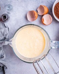 Mixing bowl with wet ingredients blended until creamy, ready for cocoa powder to be added.