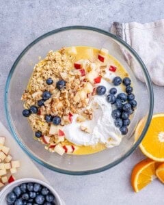 oat ingredients with yogurt and blueberries added to a bowl.