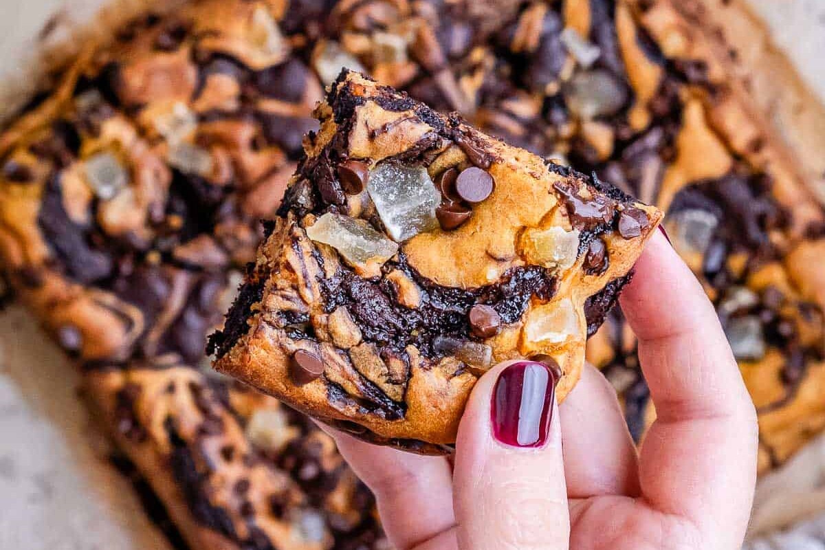 hand holding a piece of pumpkin brownie.