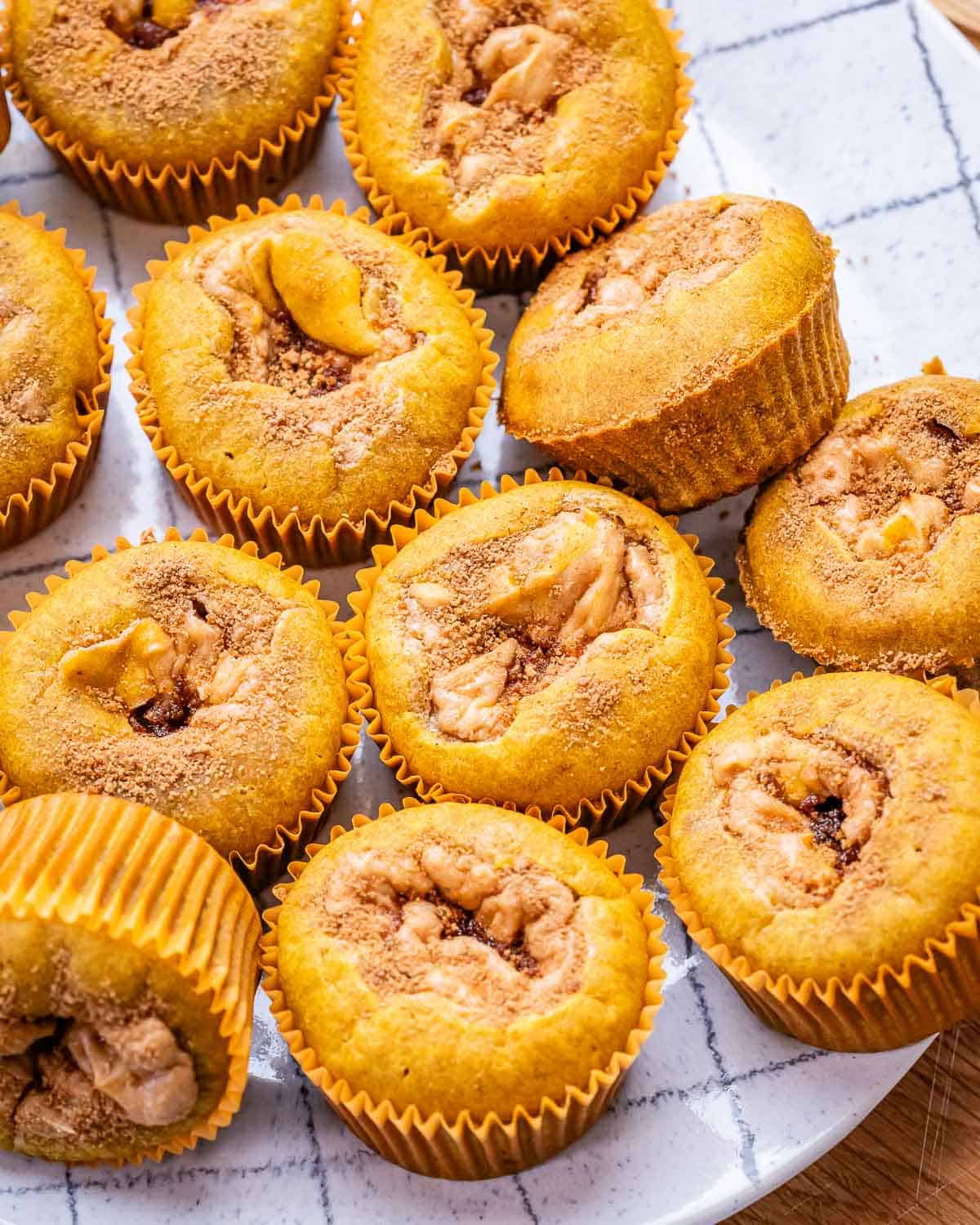 pumpkin muffins stuffed with cream cheese on a plate.