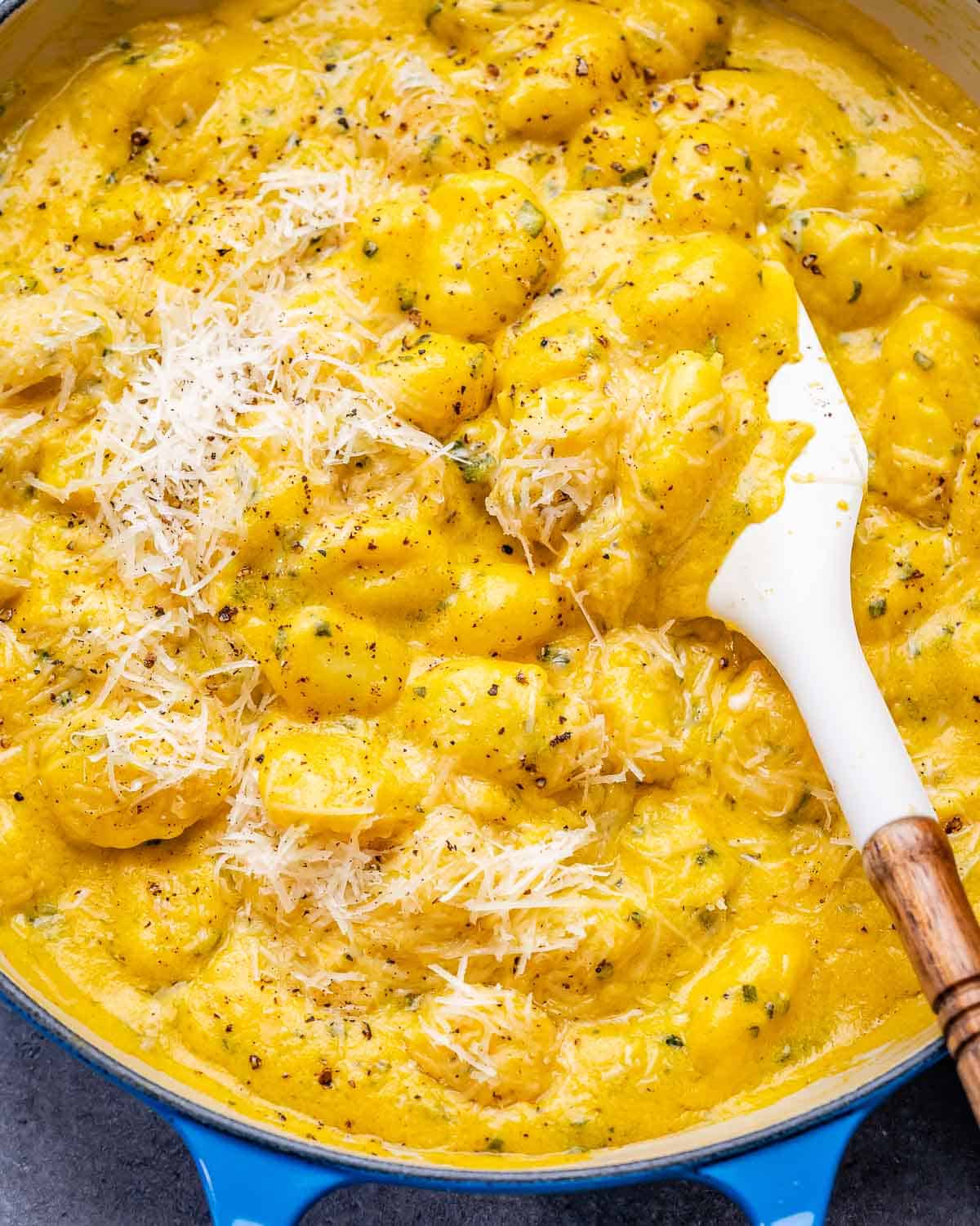 A closeup image of creamy pumpkin gnocchi in a blue skillet