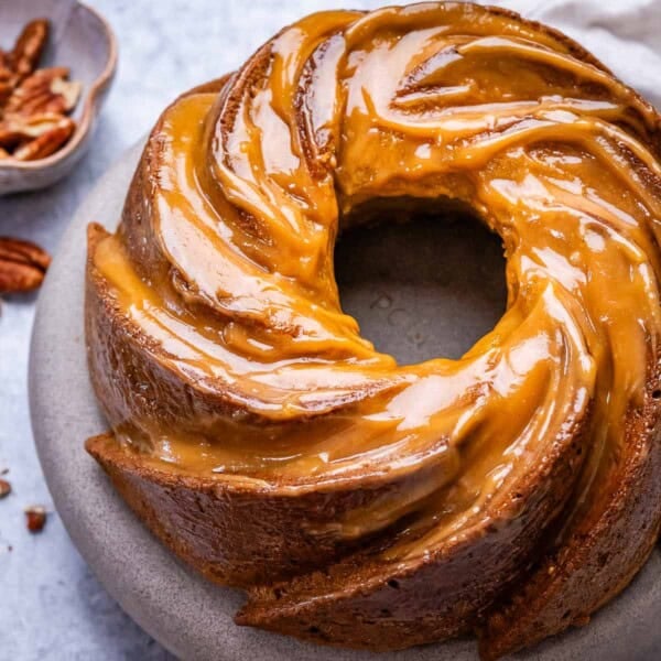 pumpkin bundt cake on a plate topped with a pumpkin glaze.