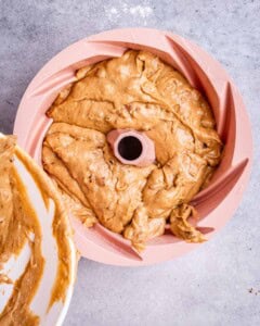 Sweet potato cake batter spread evenly in a pink silicone Bundt pan, ready to bake.