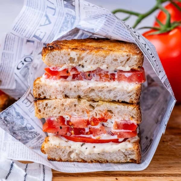 tomato sandwich cut in half and stacked on top of each other.