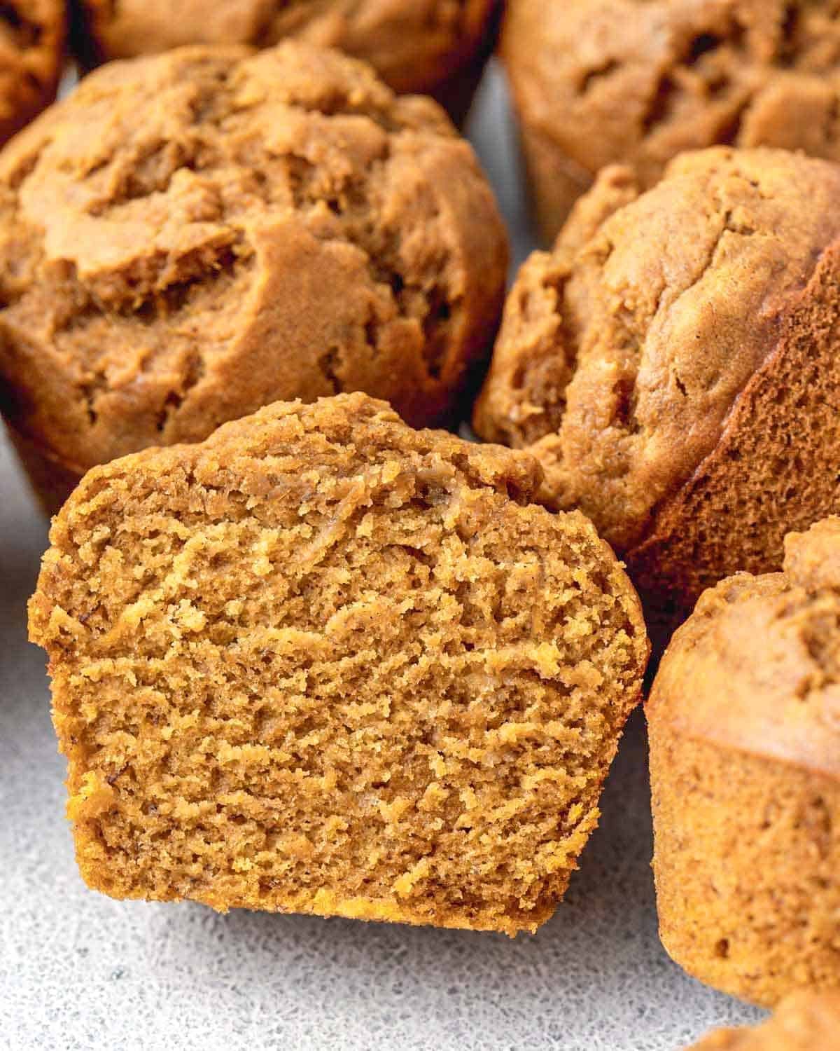 a pumpkin muffin sliced in half to show how soft and fluffy it is.