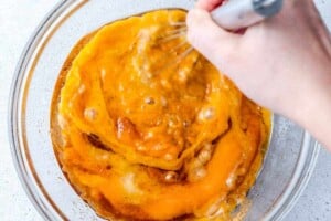 mixing the wet batter for pumpkin banana muffins in a bowl.