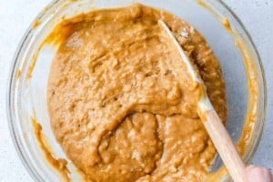 batter being mixed for the pumpkin muffins in a round bowl.