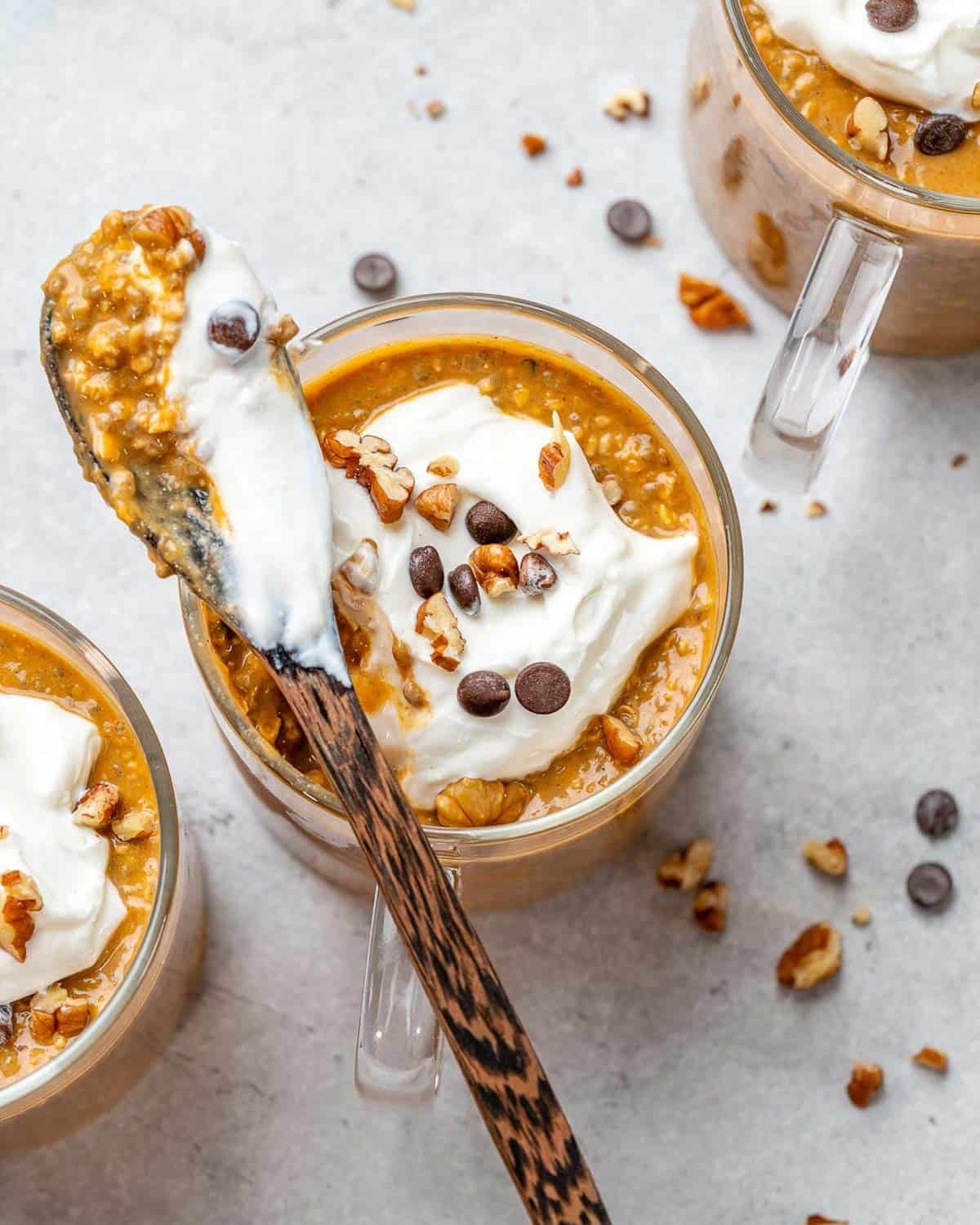 spoon dipped in a cup filled with pumpkin overnight oats.