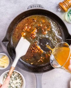 Broth is being added to the skillet.